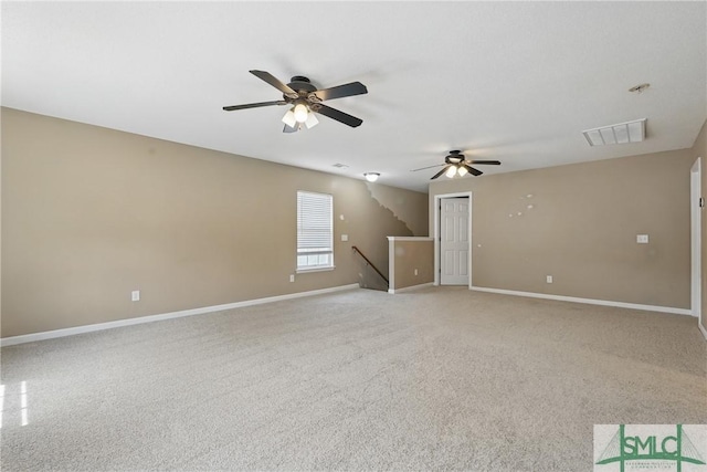 unfurnished room with a ceiling fan, baseboards, and light colored carpet