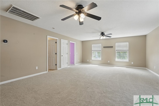 spare room with baseboards, carpet floors, a ceiling fan, and a textured ceiling
