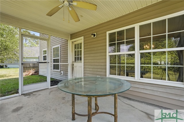 sunroom / solarium featuring a ceiling fan and outdoor dining area
