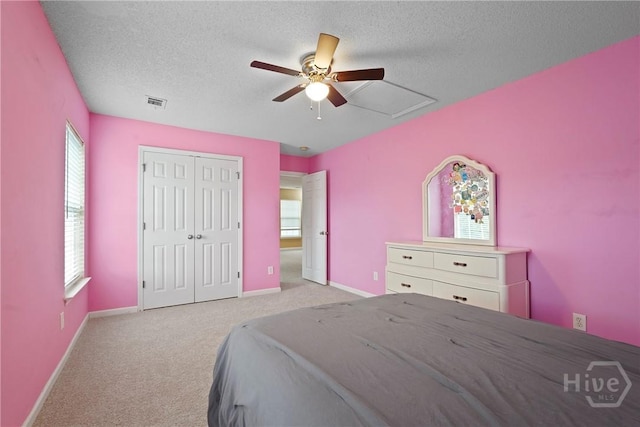 carpeted bedroom featuring a closet, a textured ceiling, a ceiling fan, and baseboards
