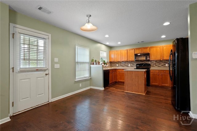 kitchen with black appliances, light countertops, dark wood-style floors, backsplash, and a center island