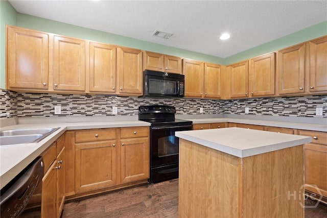 kitchen with black appliances, dark wood-style floors, a sink, light countertops, and recessed lighting