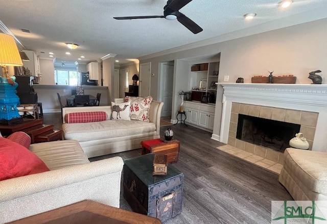 3005 River Dr Unit 401D, Savannah, GA 31404 - living room with a ceiling fan, dark wood-style flooring, ornamental molding, and a tiled fireplace