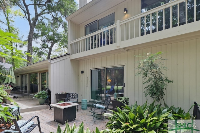 back of property featuring an outdoor fire pit and a patio