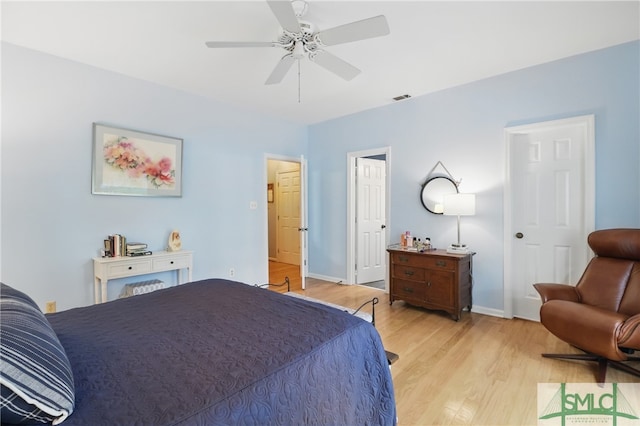 bedroom with light wood finished floors, baseboards, and a ceiling fan