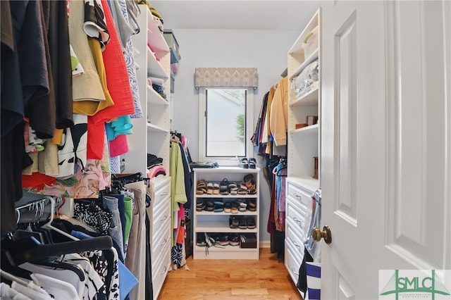 walk in closet with light wood-style flooring