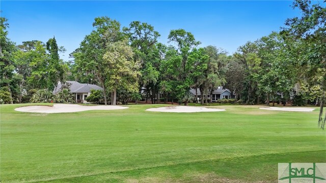 view of home's community featuring a yard, view of golf course, and view of scattered trees