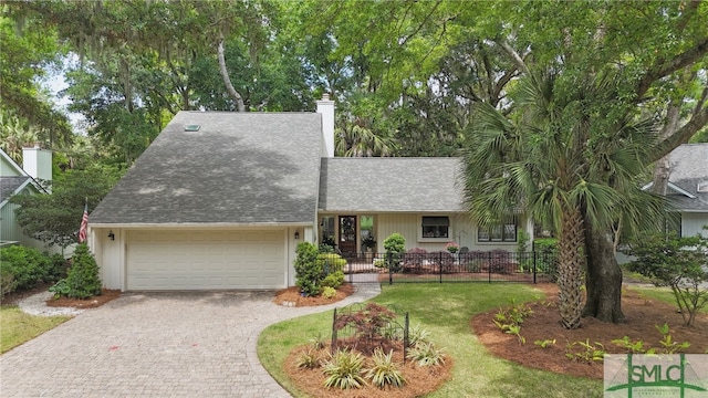 view of front of home featuring a chimney, driveway, a garage, and roof with shingles