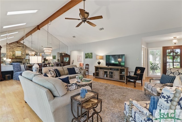 living area featuring wood finished floors, beamed ceiling, ceiling fan, and high vaulted ceiling