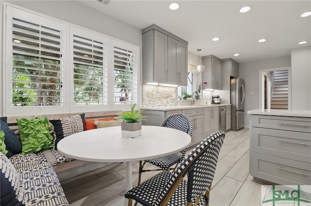 kitchen with gray cabinets, breakfast area, light countertops, plenty of natural light, and recessed lighting