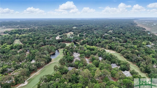 bird's eye view of a local golf course, a nearby body of water, and a heavily wooded area
