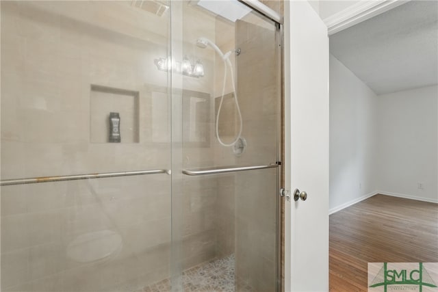 bathroom featuring wood finished floors and a stall shower