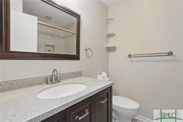 bathroom featuring vanity, toilet, and a shower with door