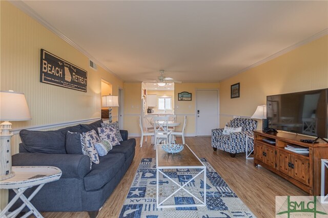 85 Van Horne Ave Unit 12A, Tybee Island, GA 31328 - living area featuring ceiling fan, wood finished floors, ornamental molding, and a wainscoted wall