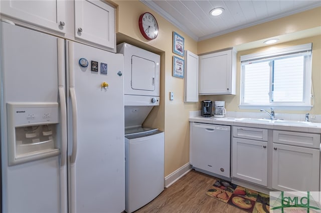 85 Van Horne Ave Unit 12A, Tybee Island, GA 31328 - clothes washing area with stacked washing machine and dryer, crown molding, wood finished floors, recessed lighting, and baseboards