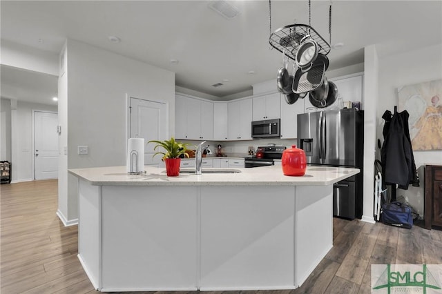 64 Southern Way, Richmond Hill, GA 31324 - kitchen featuring stainless steel appliances, wood finished floors, a center island with sink, and white cabinetry