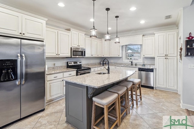 4 Honeysuckle Dr, Claxton, GA 30417 - kitchen featuring appliances with stainless steel finishes, crown molding, a center island with sink, a kitchen bar, and light stone counters