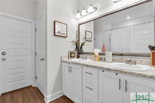 full bath featuring wood finished floors, double vanity, and a shower with curtain