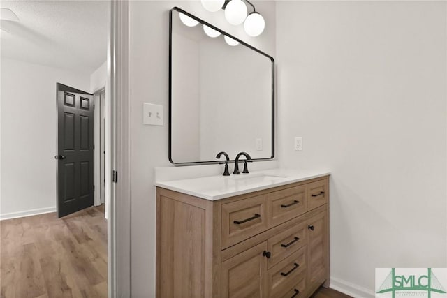 bathroom featuring wood finished floors, baseboards, and vanity