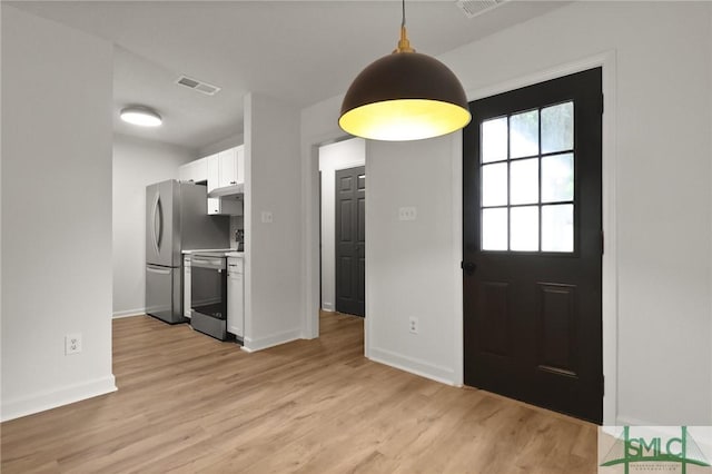 foyer entrance featuring light wood finished floors and baseboards