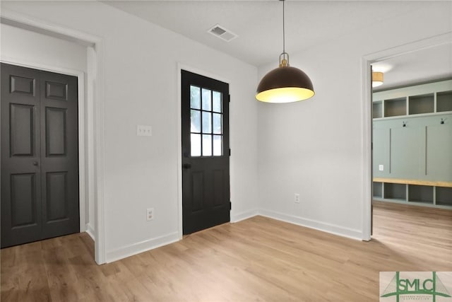 foyer entrance with baseboards and light wood-style floors