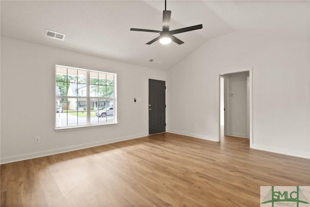 spare room featuring light wood-style floors, ceiling fan, vaulted ceiling, and baseboards