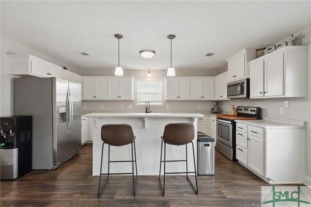 309 Nashview Trl, Allenhurst, GA 31301 - kitchen featuring appliances with stainless steel finishes, dark wood-type flooring, a kitchen bar, and a kitchen island