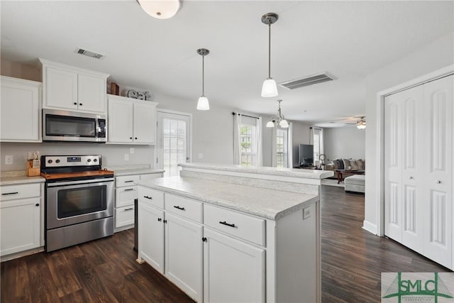 309 Nashview Trl, Allenhurst, GA 31301 - kitchen featuring stainless steel appliances, dark wood-style flooring, light countertops, white cabinetry, and a center island