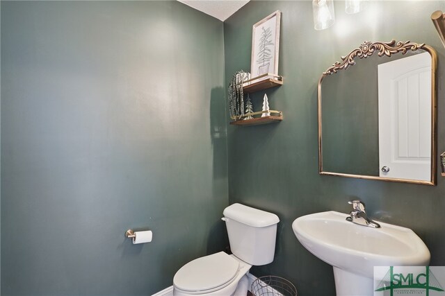 309 Nashview Trl, Allenhurst, GA 31301 - half bathroom with a sink, toilet, and baseboards