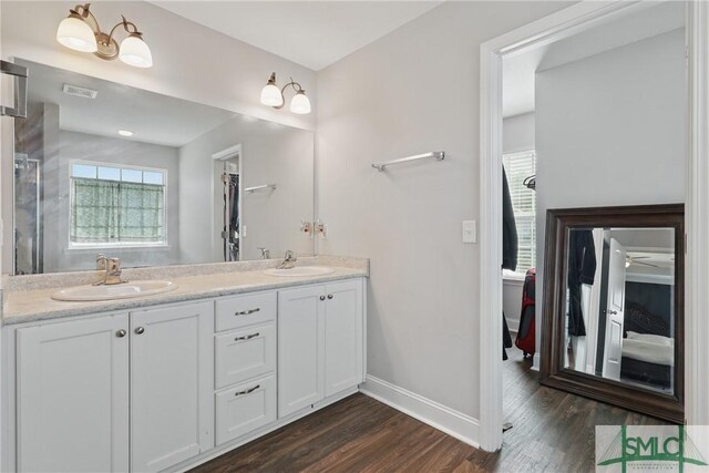 309 Nashview Trl, Allenhurst, GA 31301 - full bathroom featuring wood finished floors, baseboards, double vanity, and a shower with shower door