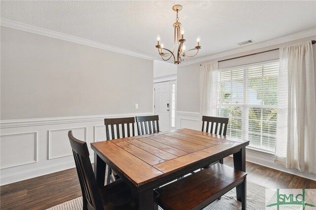 309 Nashview Trl, Allenhurst, GA 31301 - dining area with a chandelier, ornamental molding, dark wood-style floors, a decorative wall, and wainscoting