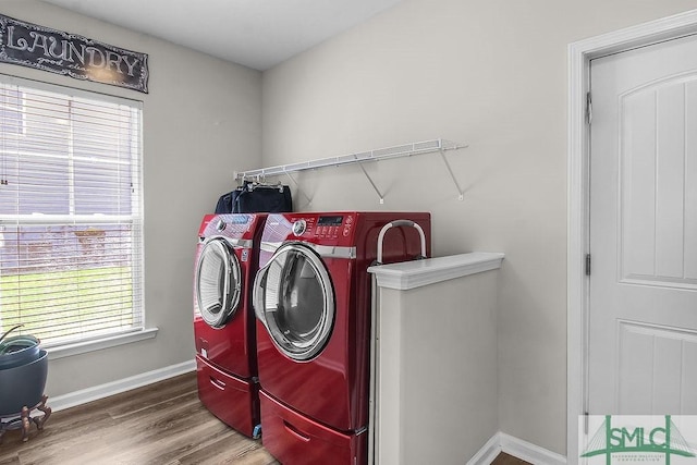 laundry area with separate washer and dryer, wood finished floors, and baseboards