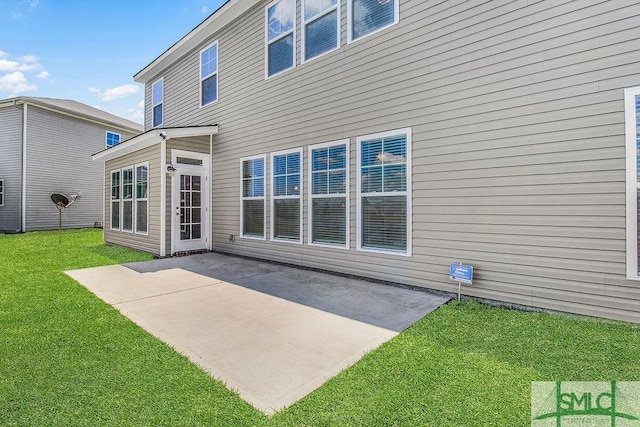 rear view of house with a patio area and a lawn