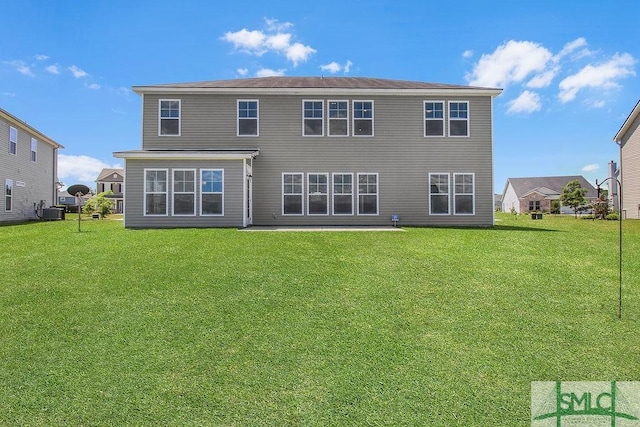 back of house featuring a lawn and central AC unit