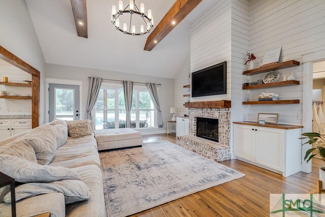 1840 Mccall Rd, Rincon, GA 31326 - living room with high vaulted ceiling, a fireplace, a chandelier, light wood-style flooring, and beam ceiling