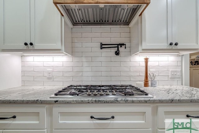 1840 Mccall Rd, Rincon, GA 31326 - kitchen with stainless steel gas stovetop, range hood, white cabinetry, tasteful backsplash, and light stone countertops