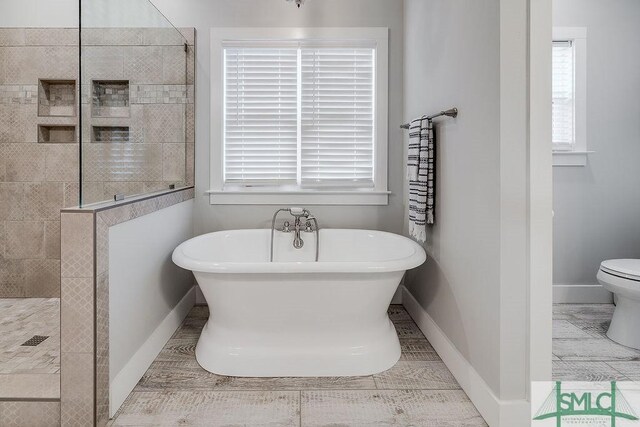 1840 Mccall Rd, Rincon, GA 31326 - bathroom featuring a freestanding bath, a walk in shower, baseboards, and toilet
