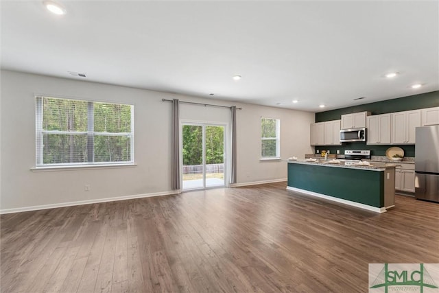 238 Sage Field Dr, Rincon, GA 31326 - kitchen featuring appliances with stainless steel finishes, open floor plan, dark wood-style floors, white cabinets, and baseboards