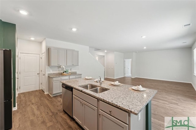 238 Sage Field Dr, Rincon, GA 31326 - kitchen featuring a sink, dishwasher, wood finished floors, freestanding refrigerator, and light stone counters