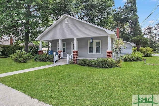 8 Georgia St, Pembroke, GA 31321 - view of front facade with a front yard, a chimney, and covered porch