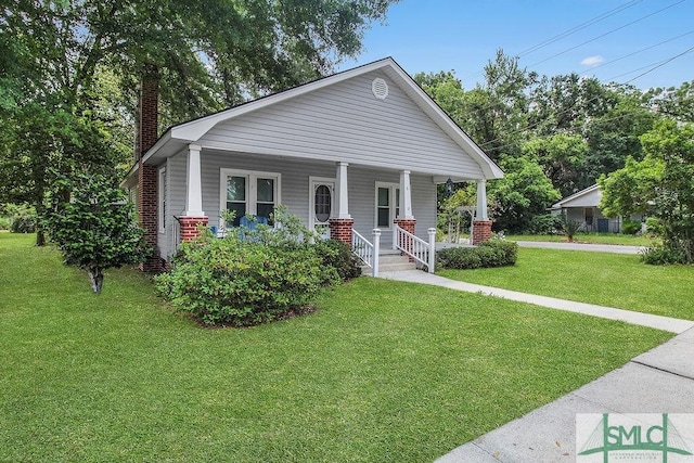 8 Georgia St, Pembroke, GA 31321 - view of front of house with a chimney, a porch, and a front lawn