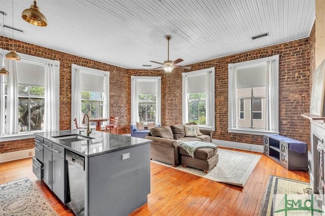20 W Oglethorpe Ave Unit D, Savannah, GA 31401 - kitchen with a sink, brick wall, dishwasher, ceiling fan, and light wood-style flooring
