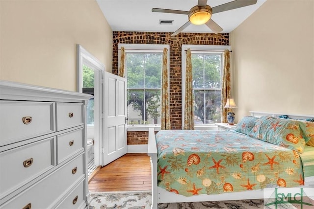 20 W Oglethorpe Ave Unit D, Savannah, GA 31401 - bedroom with brick wall, light wood-style floors, a ceiling fan, and baseboards