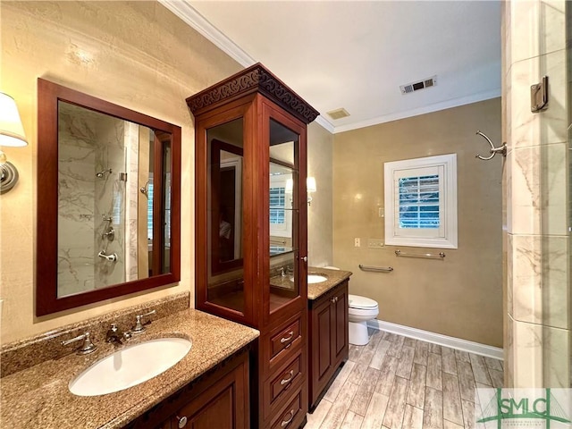 bathroom with crown molding, a shower, toilet, vanity, and wood finished floors