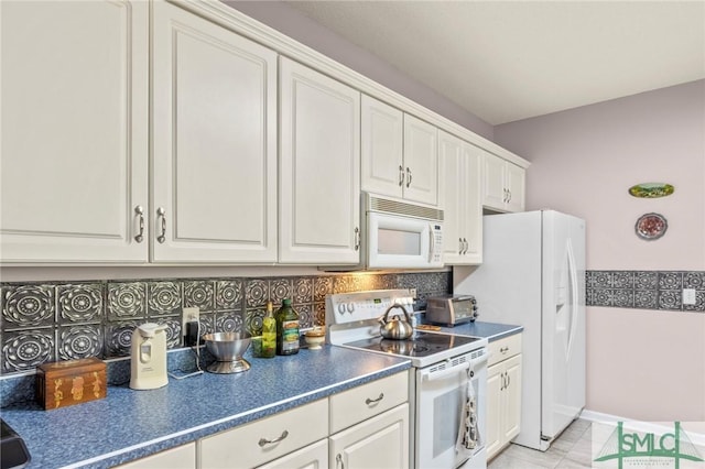 330 Central Ave, Guyton, GA 31312 - kitchen featuring white appliances, tasteful backsplash, dark countertops, white cabinets, and light tile patterned floors