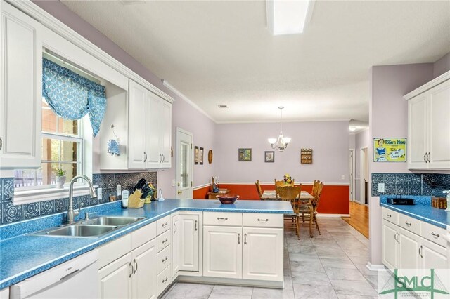 330 Central Ave, Guyton, GA 31312 - kitchen with white dishwasher, a sink, a peninsula, white cabinets, and a chandelier