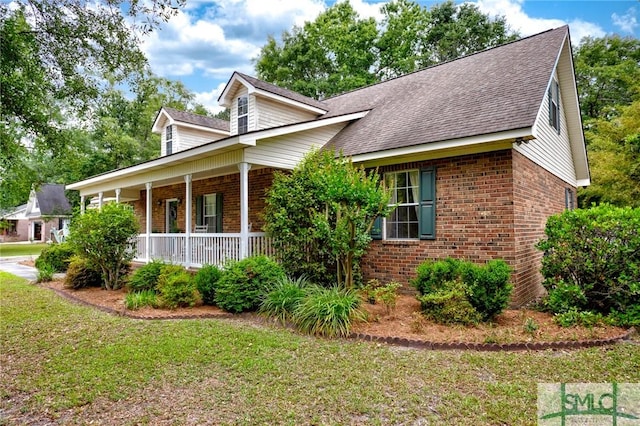 330 Central Ave, Guyton, GA 31312 - view of front of house with brick siding, covered porch, roof with shingles, and a front yard