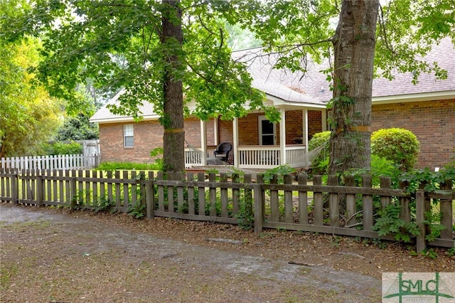 330 Central Ave, Guyton, GA 31312 - view of front of home with covered porch, a fenced front yard, and brick siding