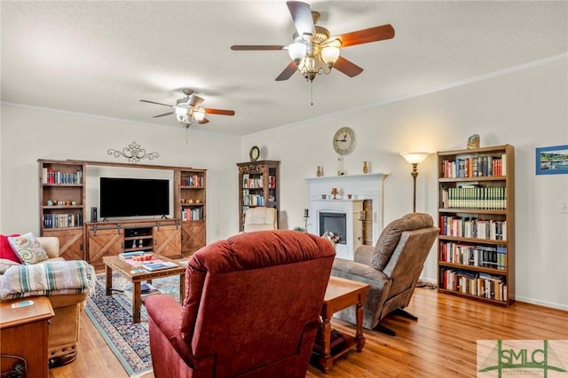 330 Central Ave, Guyton, GA 31312 - living room featuring light wood-style floors, a fireplace, a ceiling fan, ornamental molding, and a textured ceiling