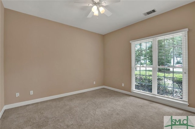 carpeted empty room featuring baseboards and ceiling fan